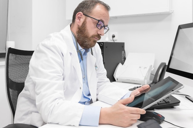 Médico usando seu computador tablet no trabalho