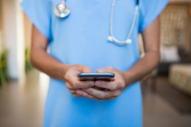 Médico usando telefone celular no hospital