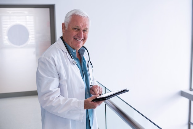 Médico usando um tablet digital na passagem do hospital