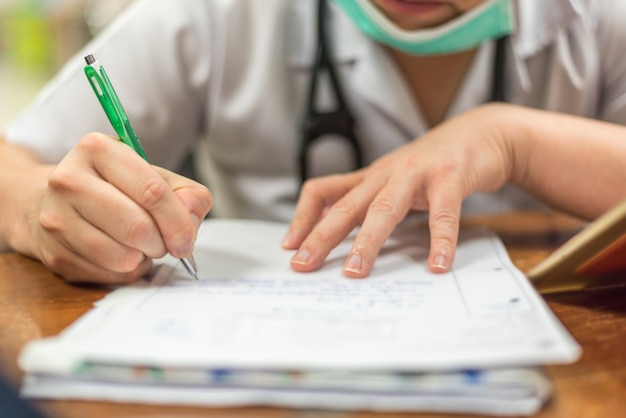 Foto médico usar uma caneta escrevendo sobre cuidados de saúde e remédio em papel ou prescrição de documentos