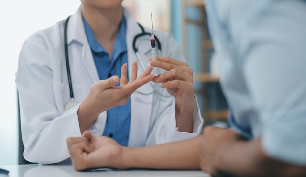 El médico utiliza una aguja hipodérmica y una jeringa para poner una dosis de medicamento como tratamiento