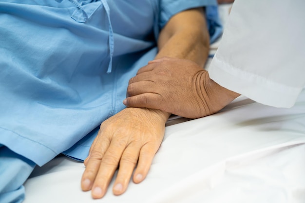 Foto el médico utiliza el estetoscopio para comprobar el paciente acostarse en una cama en el hospital saludable fuerte concepto médico