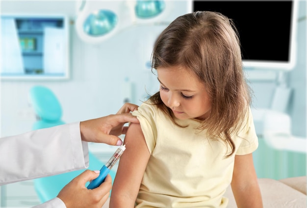 Médico vacinando garotinha isolada em um fundo branco