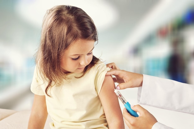 Médico vacinando garotinha isolada no fundo