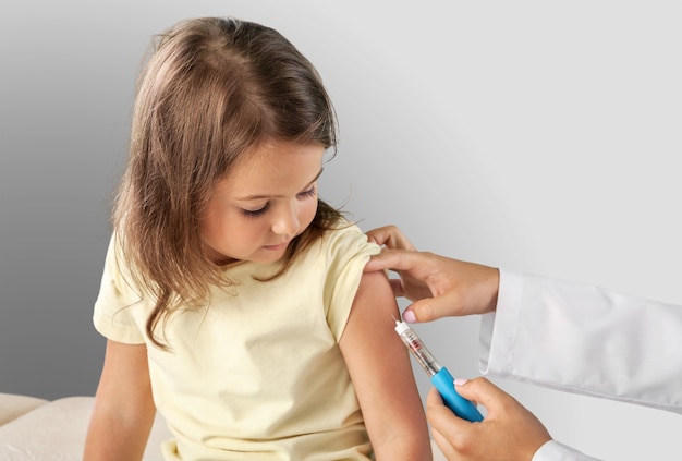 Médico vacinando menina isolada em um fundo branco