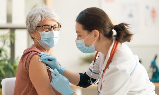 Foto médico vacinando uma mulher idosa proteção contra vírus covid2019