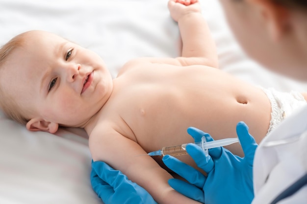 Médico vacunando a un bebé en una clínica Niño pequeño recibe una inyección Pediatra vacunando a un recién nacido Vacuna