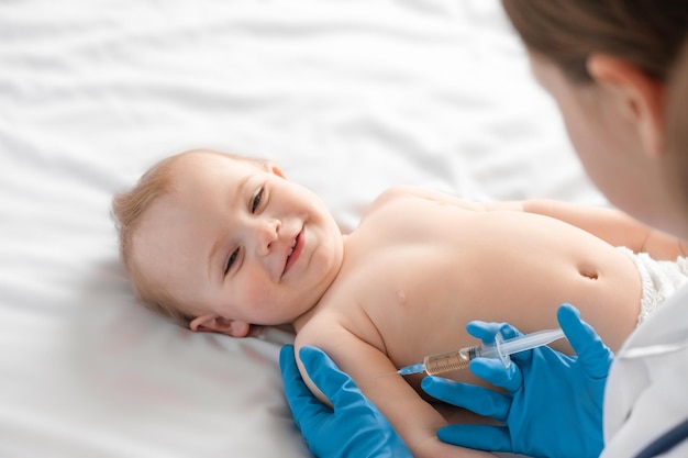 Médico vacunando a un bebé en una clínica Niño pequeño recibe una inyección Pediatra vacunando a un recién nacido Vacuna