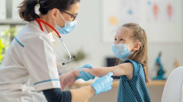 Foto médico vacunar al niño en el hospital.