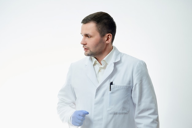 Médico varón caucásico lleva una bata blanca de laboratorio