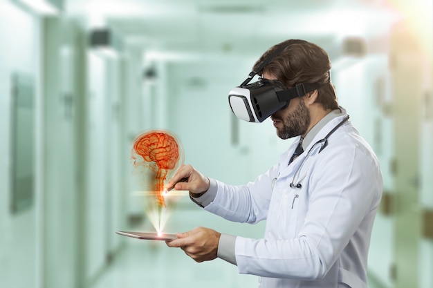 Médico varón en un hospital mirando un cerebro virtual que sale de una tableta