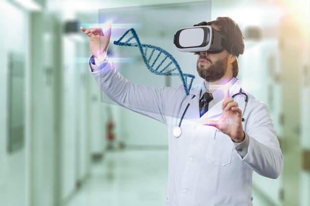 Médico varón en un hospital, utilizando unas gafas de realidad virtual, mirando un ADN virtual