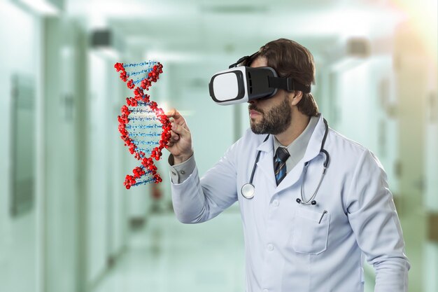 Médico varón en un hospital, utilizando unas gafas de realidad virtual, mirando un ADN virtual