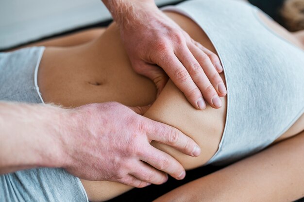 Foto médico varón y paciente durante una sesión de masaje de fisioterapia