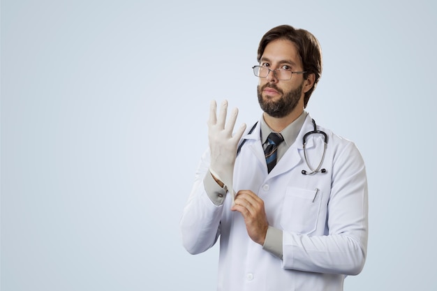 Médico varón, poniéndose guantes de látex.