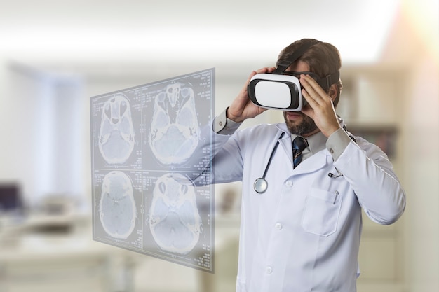 Médico varón en su oficina, utilizando unas gafas de realidad virtual, mirando una pantalla virtual