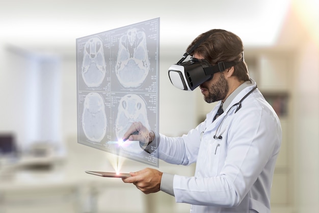 Médico varón en su oficina, utilizando unas gafas de realidad virtual, mirando una pantalla virtual