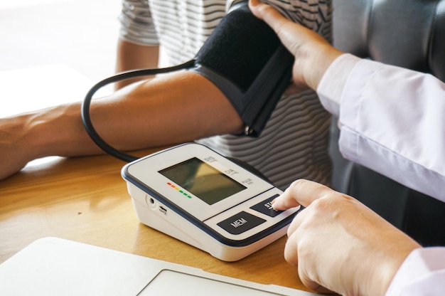 Médico verificando a pressão arterial do paciente Cuidados de saúde