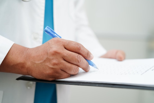 Foto médico verificando e anotando medicamento de diagnóstico na área de transferência de pacientes no hospital