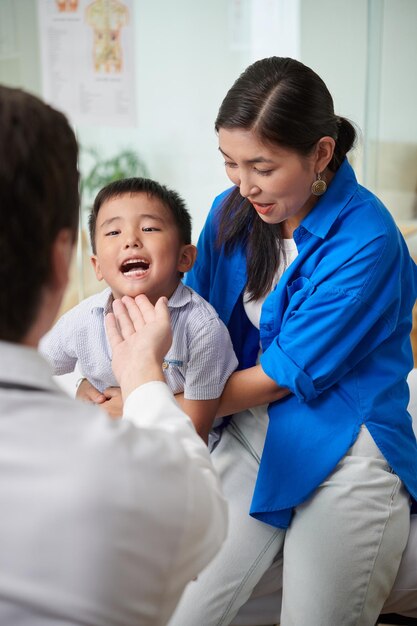 Médico verificando garganta de meninos
