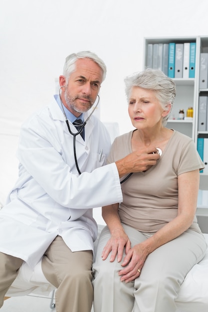 Médico verificando os batimentos cardíacos do paciente usando estetoscópio