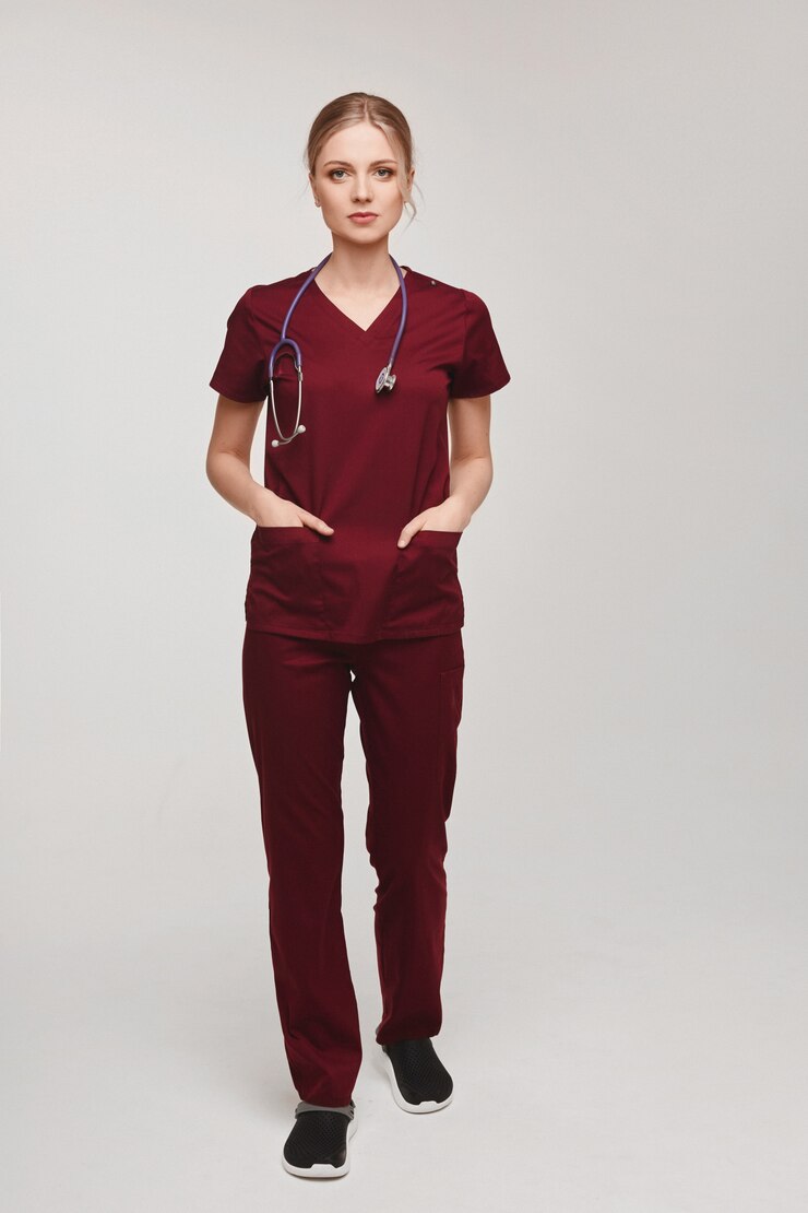 Foto médico veterinário de mulher jovem e bonita de uniforme com estetoscópio posando de comprimento total em um cinza