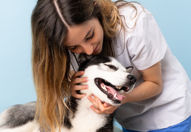 Foto médico veterinário na clínica veterinária com cão husky siberiano