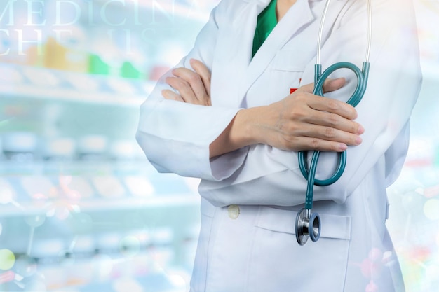 Médico viste uniforme blanco Soporte médico con los brazos cruzados y mano sosteniendo estetoscopio Salud