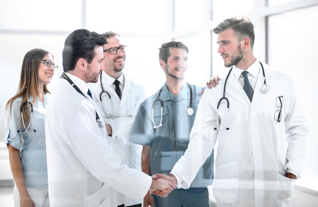 Médicos, apertando as mãos no corredor do hospital