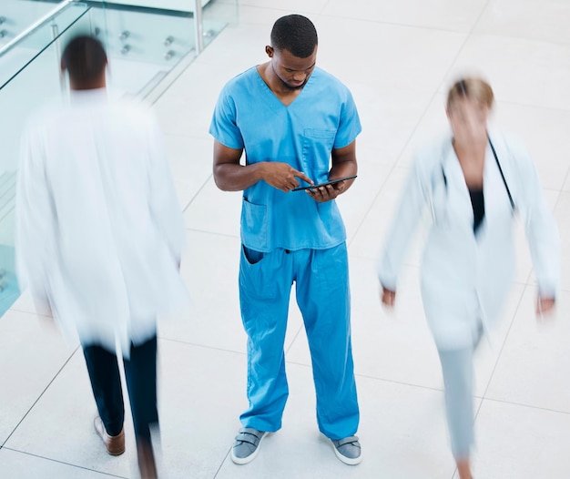 Médicos de atención médica y una enfermera en una tableta en un pasillo de hospital o clínica Trabajador médico que consulta el historial de pacientes en línea antes de la cirugía Trabajo en equipo de gestión e innovación para ayudar a la atención médica