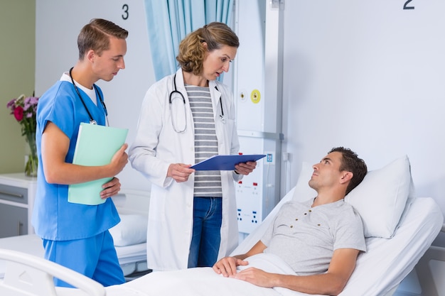 Médicos conversando com o paciente na cama do hospital
