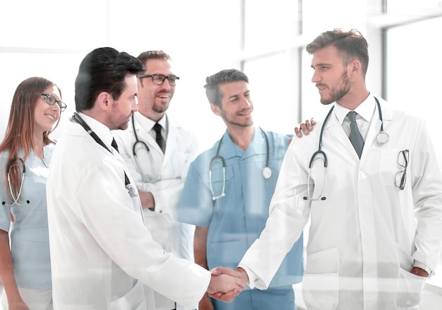 Médicos dándose la mano en el pasillo del hospital