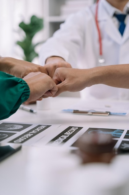 Médicos dándose la mano trabajando juntos como equipo en el hospital