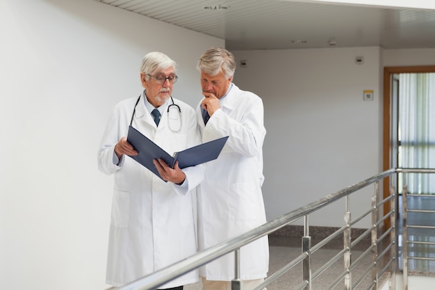 Médicos de pé no corredor falando