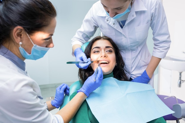 Médicos dentistas examinando paciente os dentistas estão trabalhando