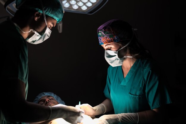 Foto médicos durante a operação na sala de cirurgia do hospital com paciente