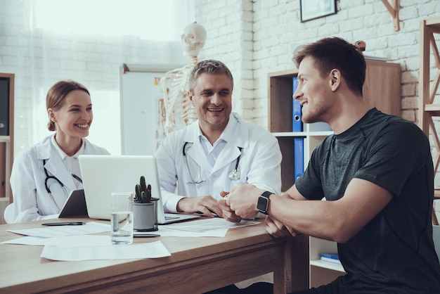 Médicos e atleta estão falando no quarto