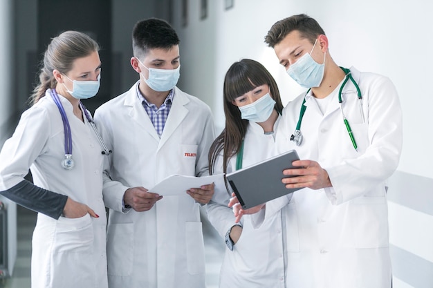 Foto médicos em máscaras usando o tablet