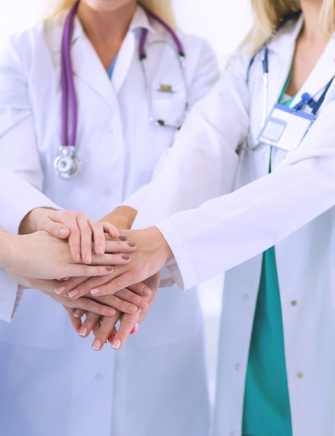 Médicos y enfermeras en un equipo médico apilando las manos
