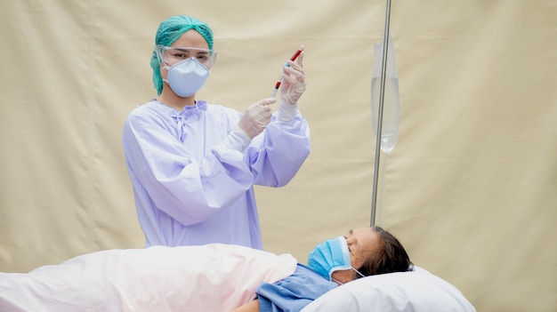 Los médicos llevaban un tubo de sujeción de máscara para recolectar muestras de sangre de los pacientes ancianos.