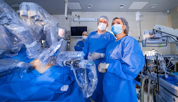 Los médicos miran pantallas con un proceso de operación de trabajo. Los médicos controlan el flujo de trabajo de la operación quirúrgica. Equipo moderno en clínica.