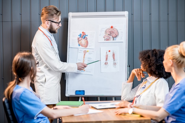 Médicos multiétnicos em conferência com quadro branco no escritório moderno