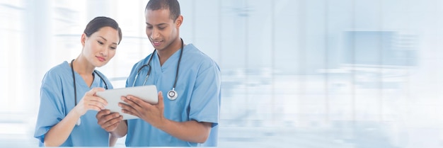 Médicos olhando para um tablet contra um fundo azul