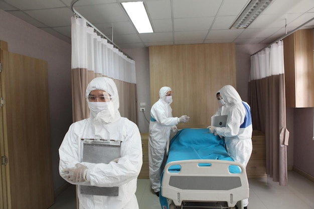 Foto médicos de pie junto a la cama en el hospital