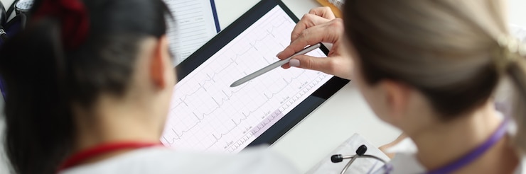 Foto médicos que estudian electrocardiograma en primer plano de tableta digital