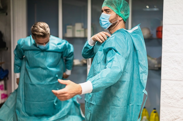 Médicos que se preparan para trabajar en el hospital para una operación quirúrgica dentro de un hospital privado: se centran en la cara del hombre correcto