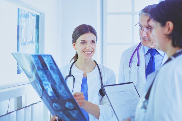 Médicos sonrientes discutiendo el diagnóstico del paciente mirando radiografías en un hospital