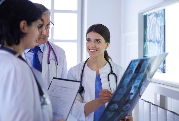 Médicos sonrientes discutiendo el diagnóstico del paciente mirando radiografías en un hospital