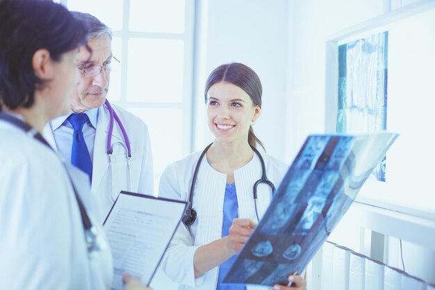 Médicos sonrientes discutiendo el diagnóstico del paciente mirando radiografías en un hospital