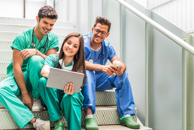 Médicos tomando café y viendo tableta